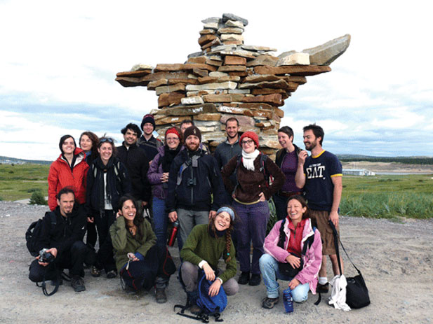 Étudiants de l'UQAM devant un inukshuk (monument de pierres) dans le Nord.